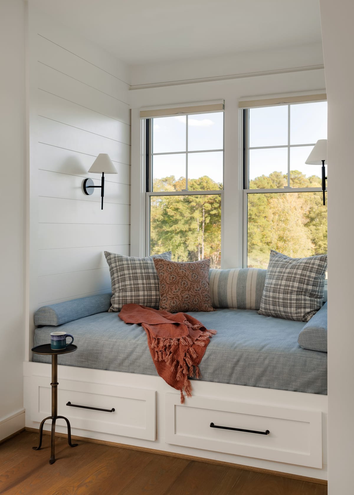 Built in window seat with plaid pillows overlooking the lake