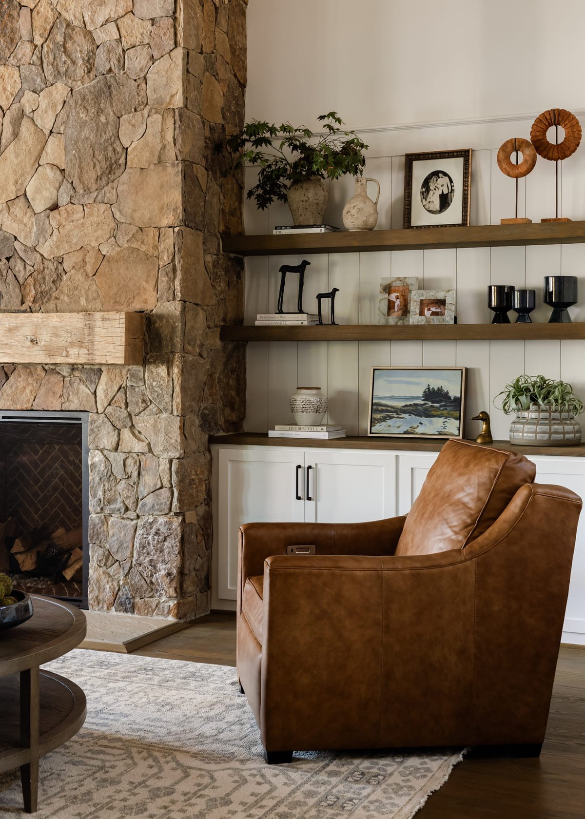 Stone fireplace with a leather swivel chair and built in shelving