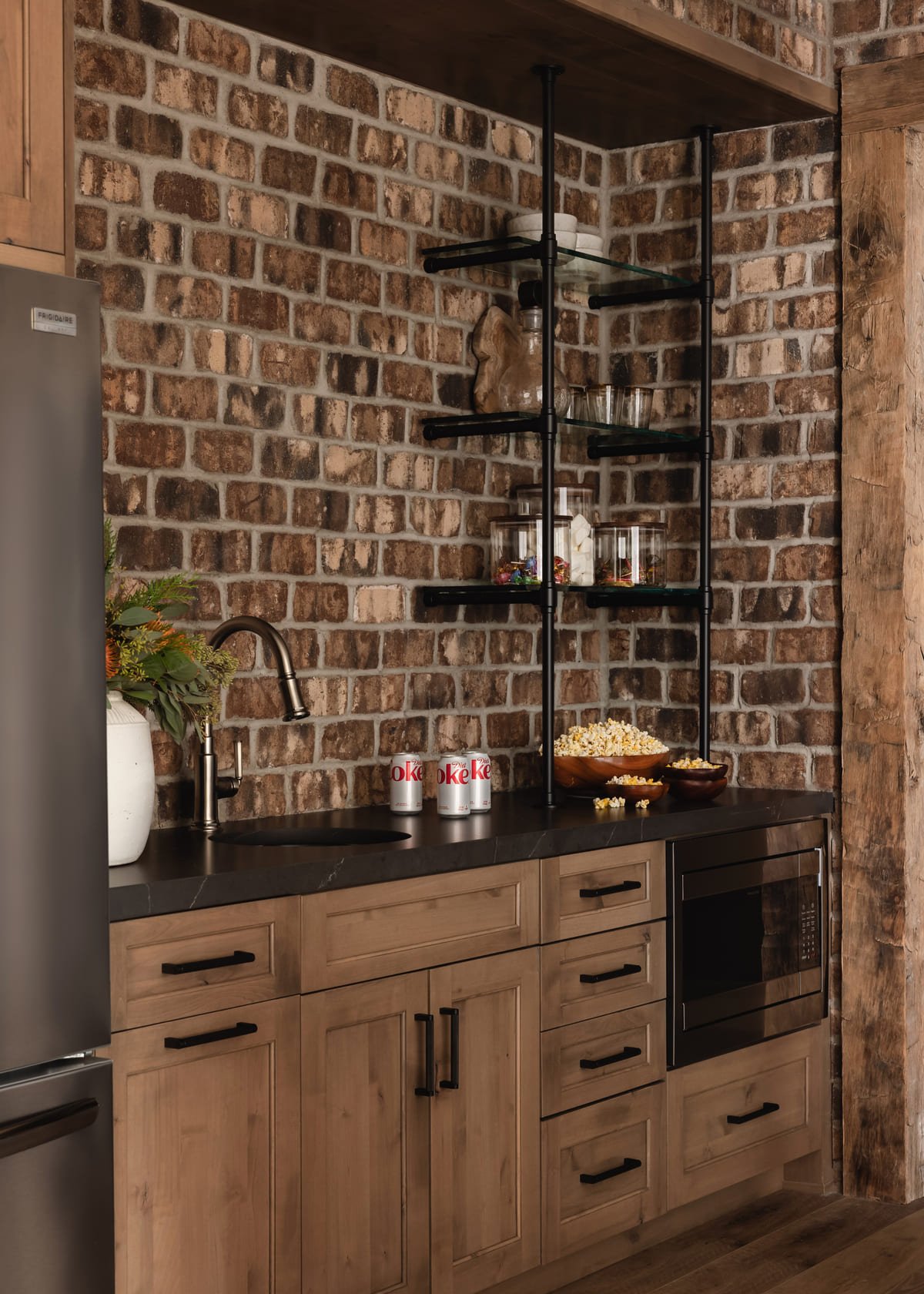 Bar with a brick backsplash, black open shelving, and a beverage center