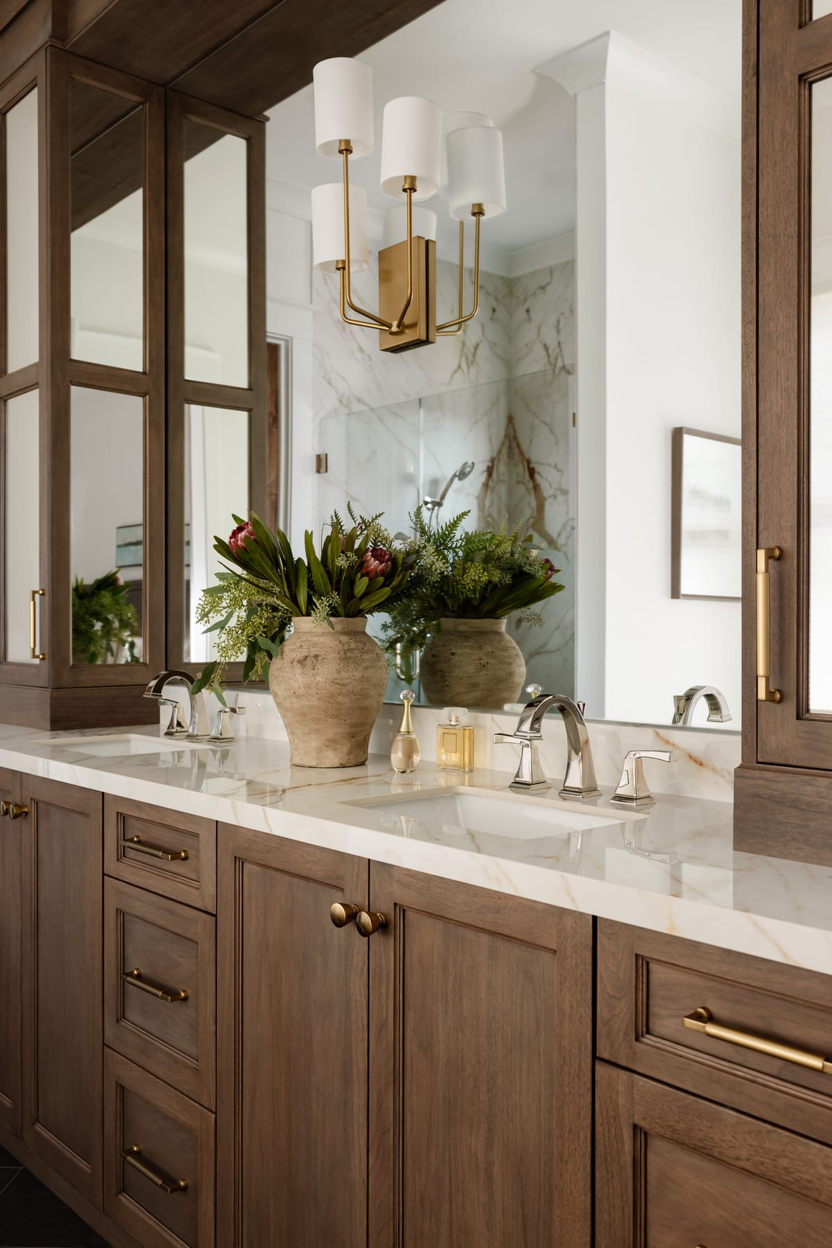 Double vanity in rift oak with a marble counter and layered mirrors