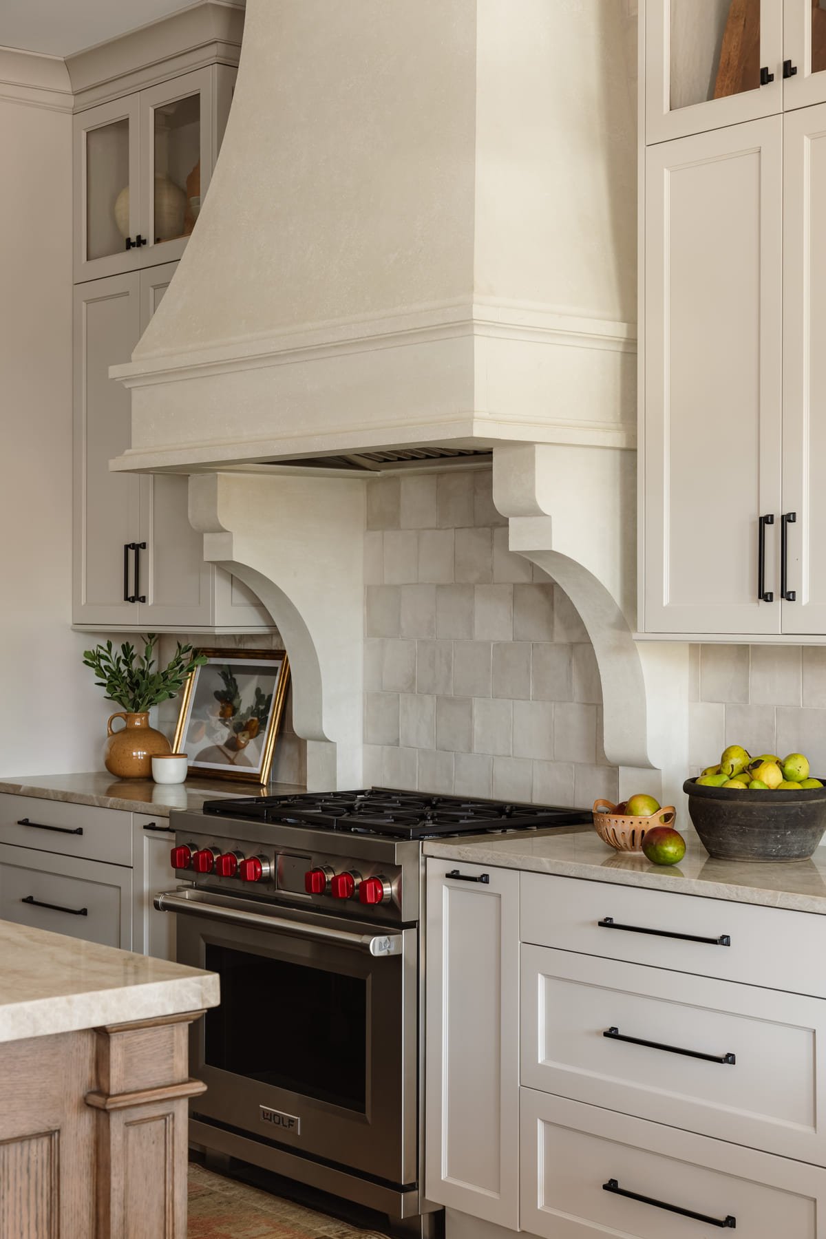 Plaster range hood above a professional range in a lake house kitchen