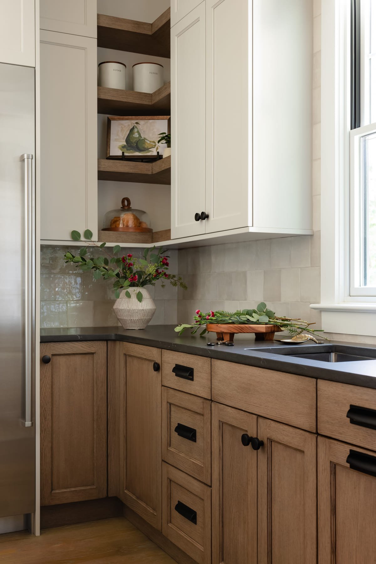 Oak kitchen cabinetry with soapstone counters and a garden window
