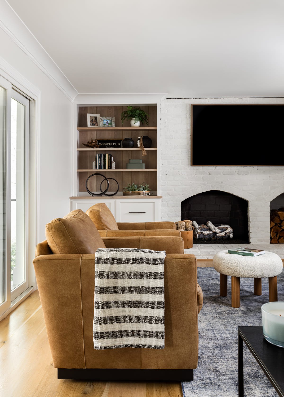 Living room with caramel swivel chairs beside a white fireplace