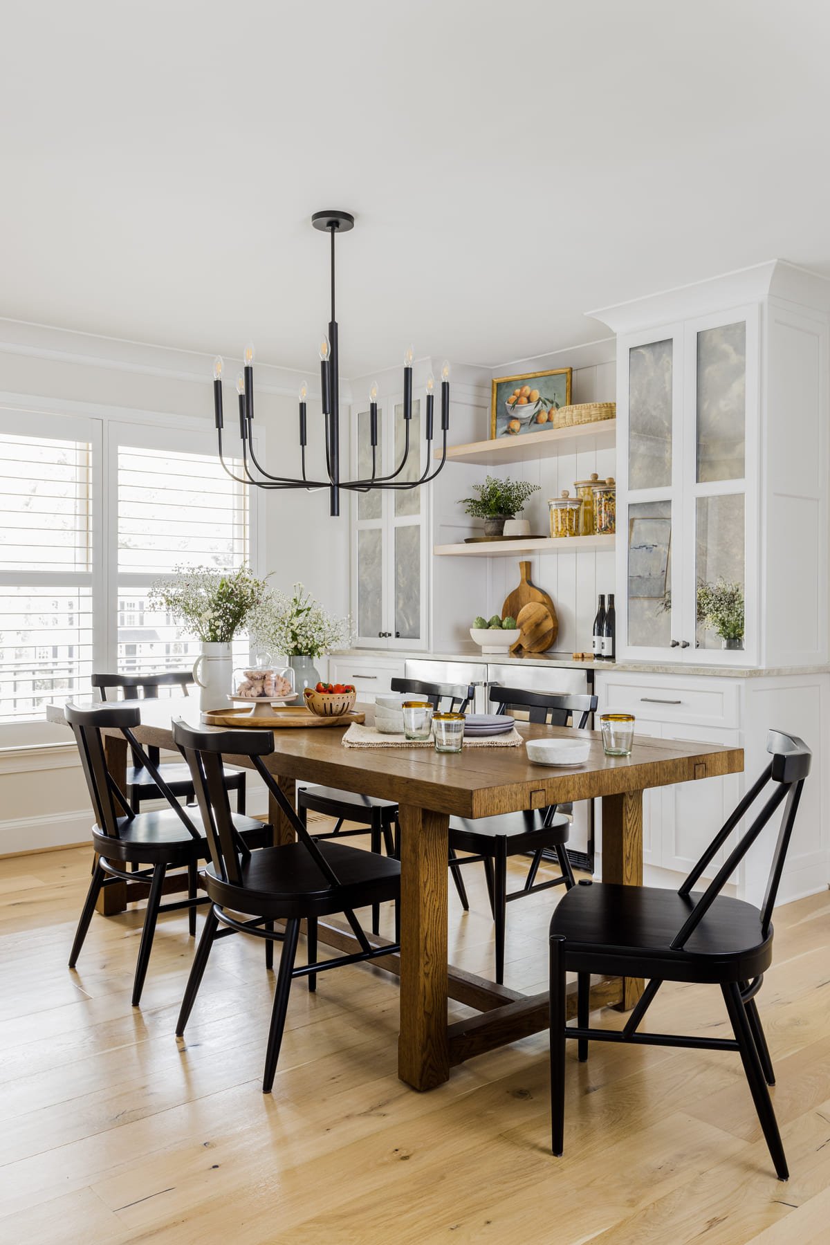 Dining room with black spindle chairs under an iron chandelier