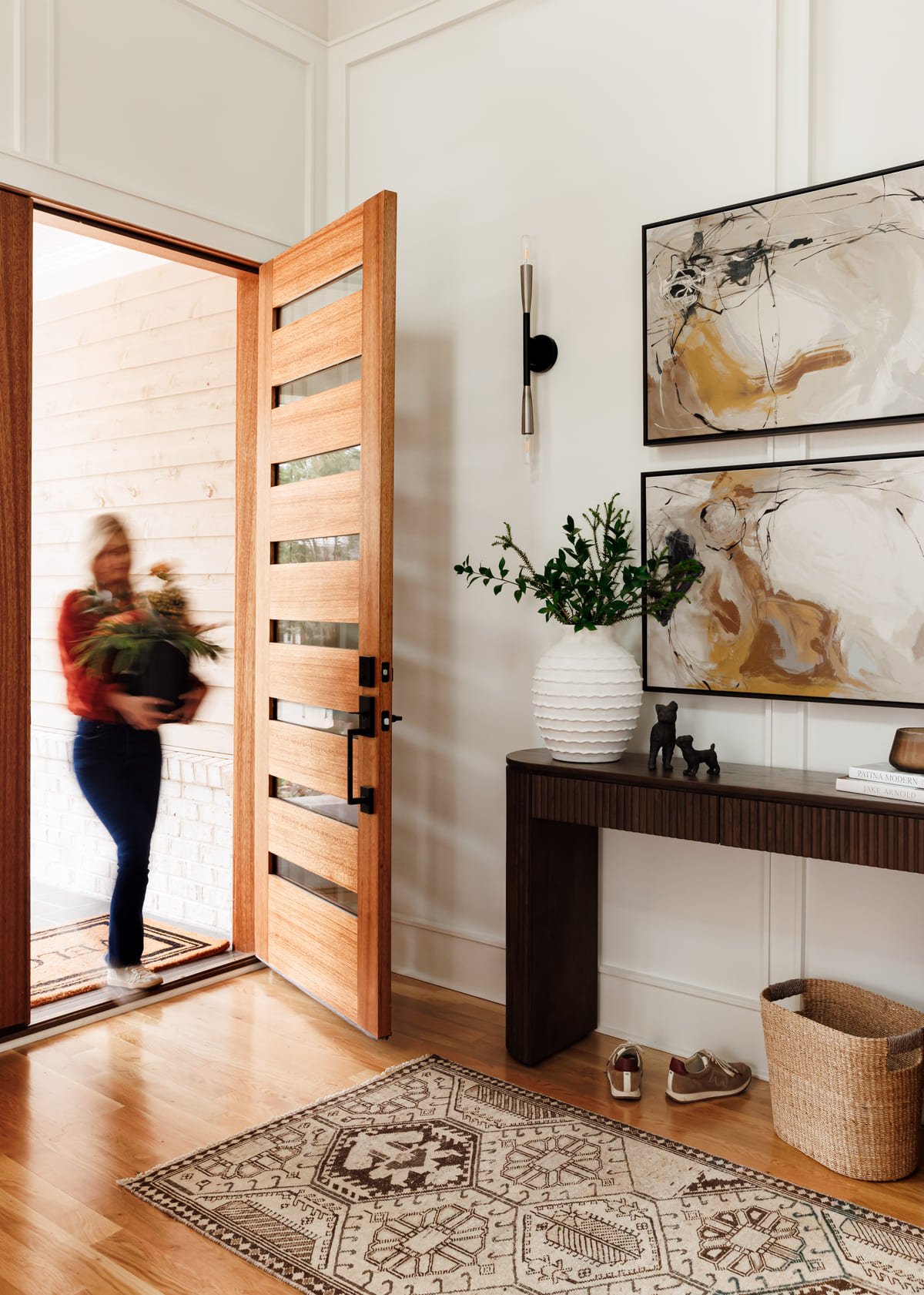 Entry with a wood front door, console table, and vintage runner