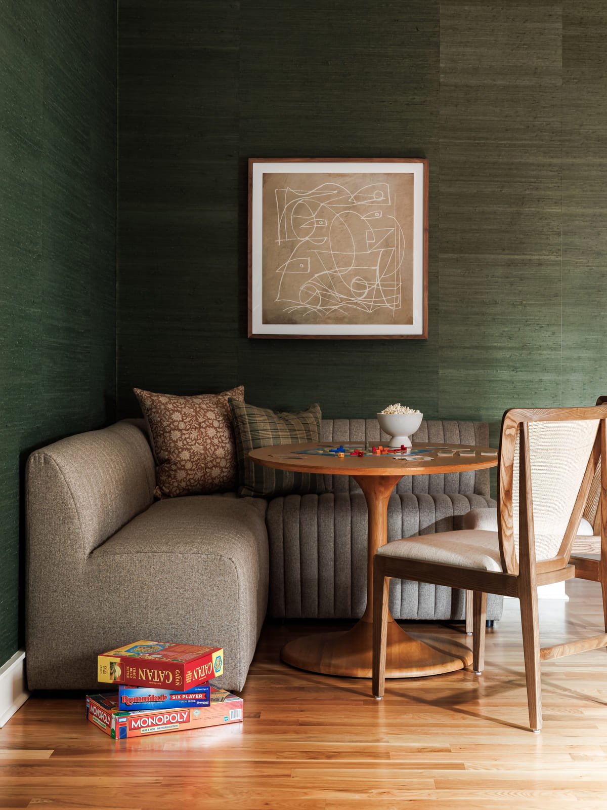 Breakfast nook with green grasscloth walls and a curved banquette
