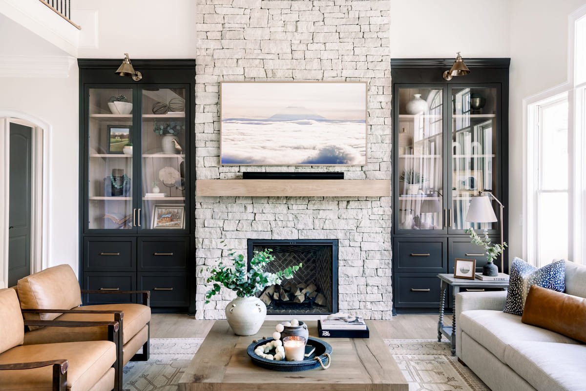 Living room with black cabinetry flanking a stone fireplace