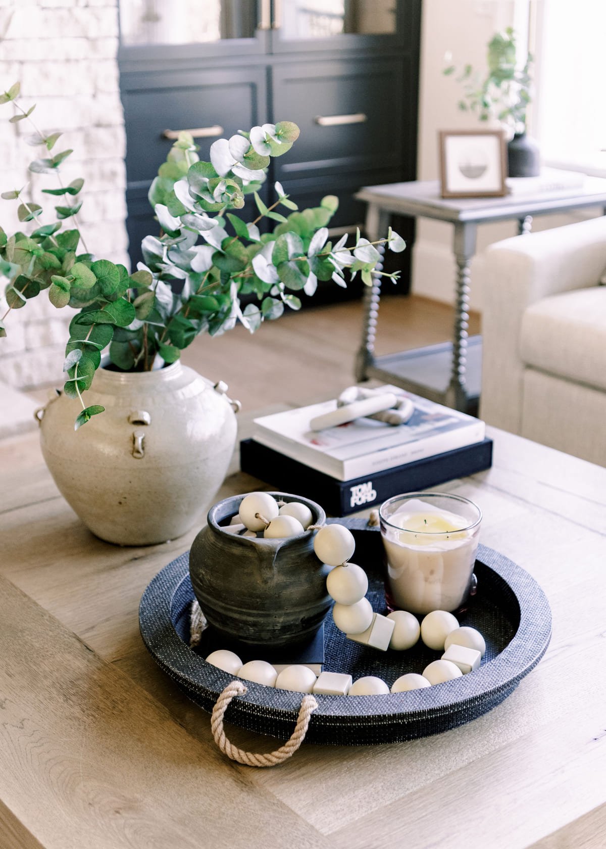 Coffee table vignette with a wooden bead garland and stacked books