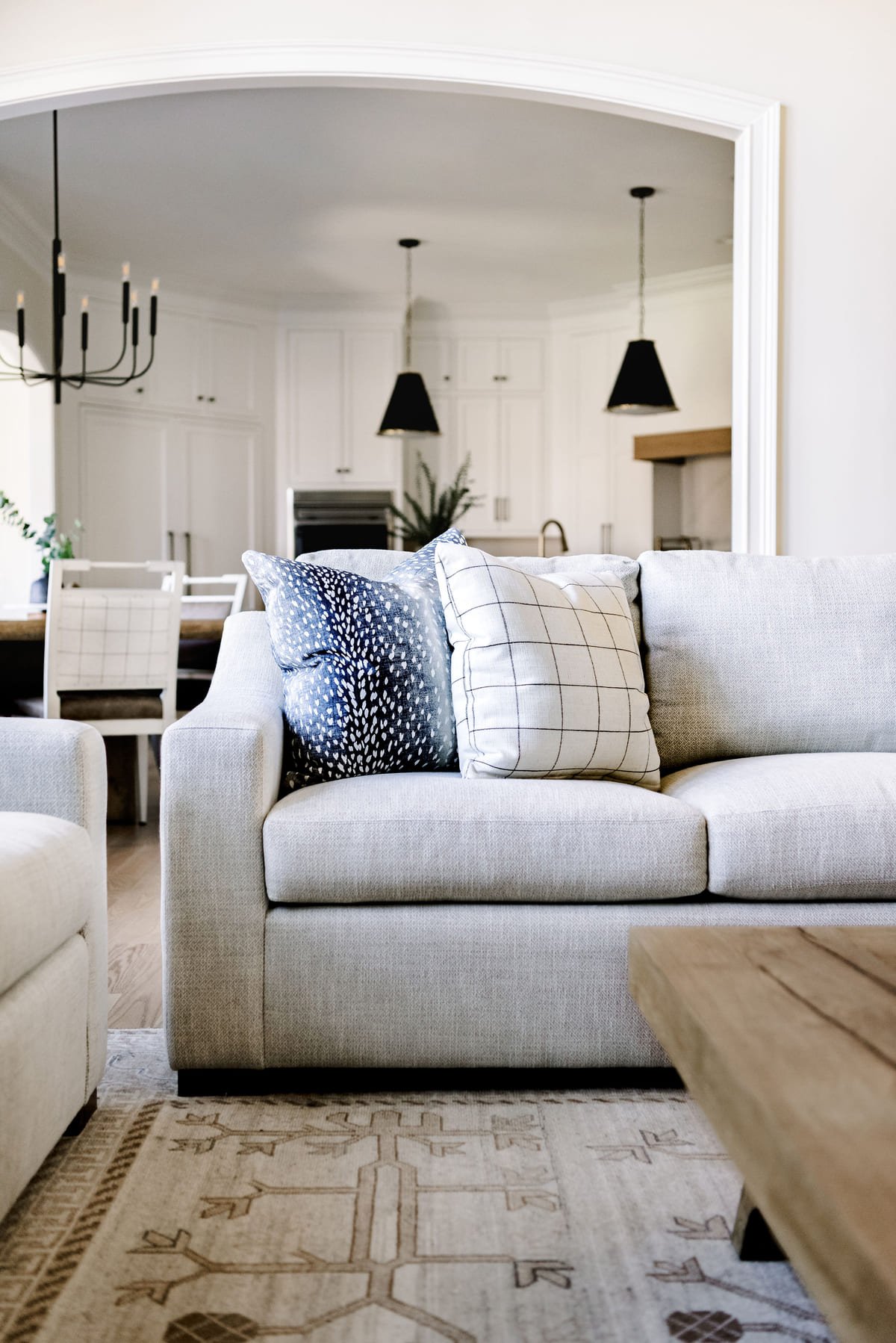 Great room seen through an arched opening with a gray sectional