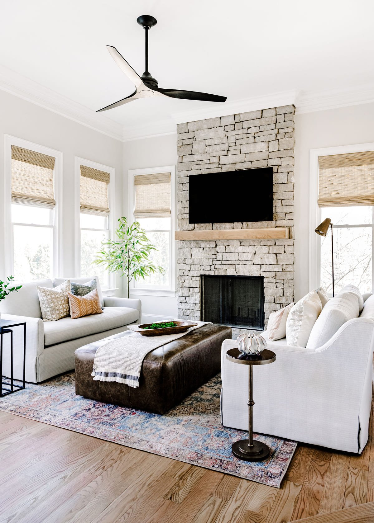 Two story stone fireplace anchoring a light filled great room
