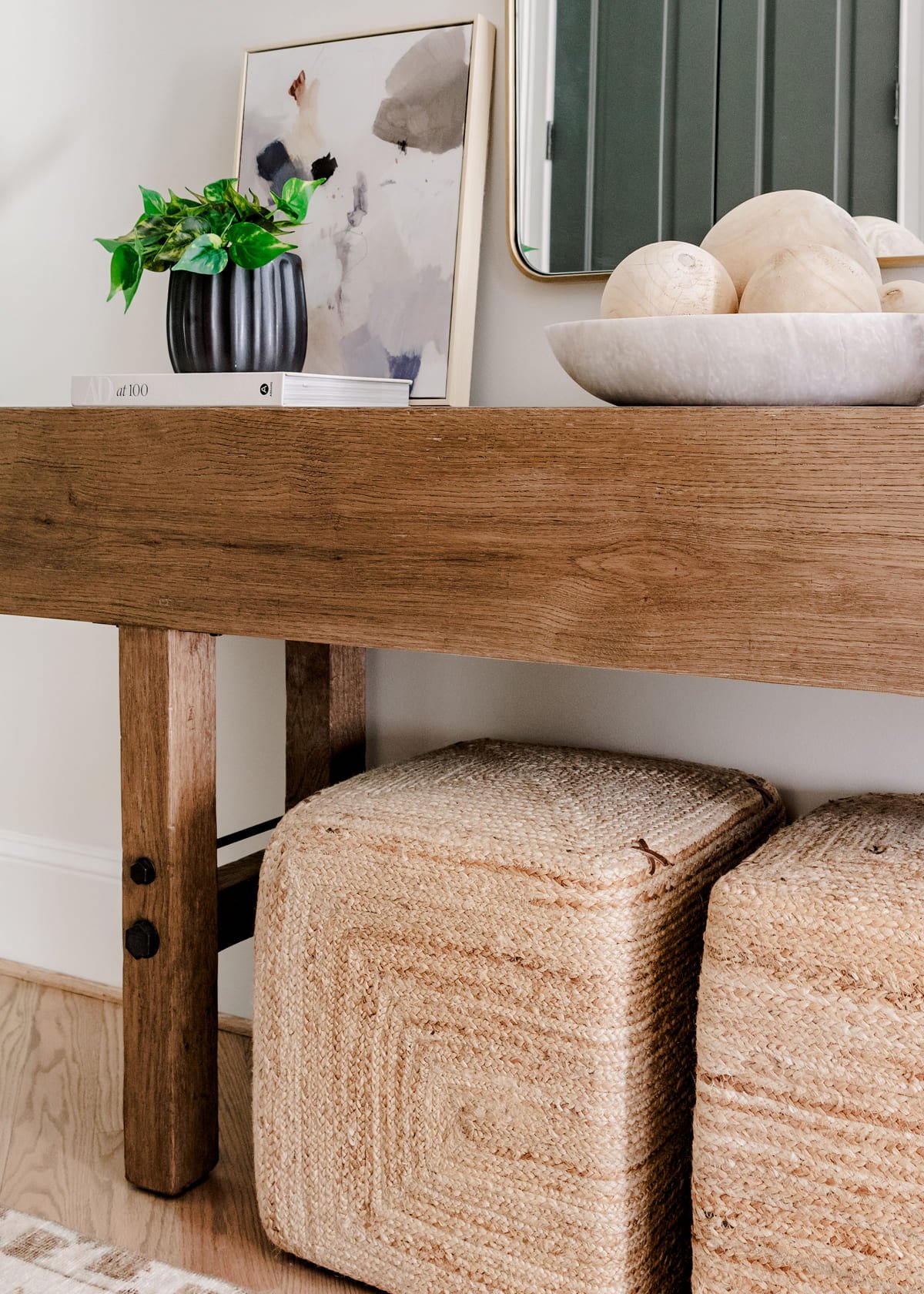 Console vignette with sculptural objects against green paneling