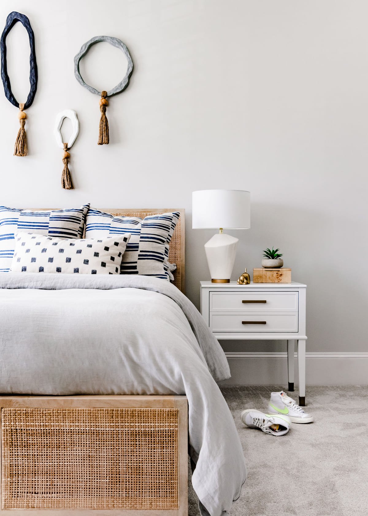 Guest bedroom with a woven headboard and layered striped bedding