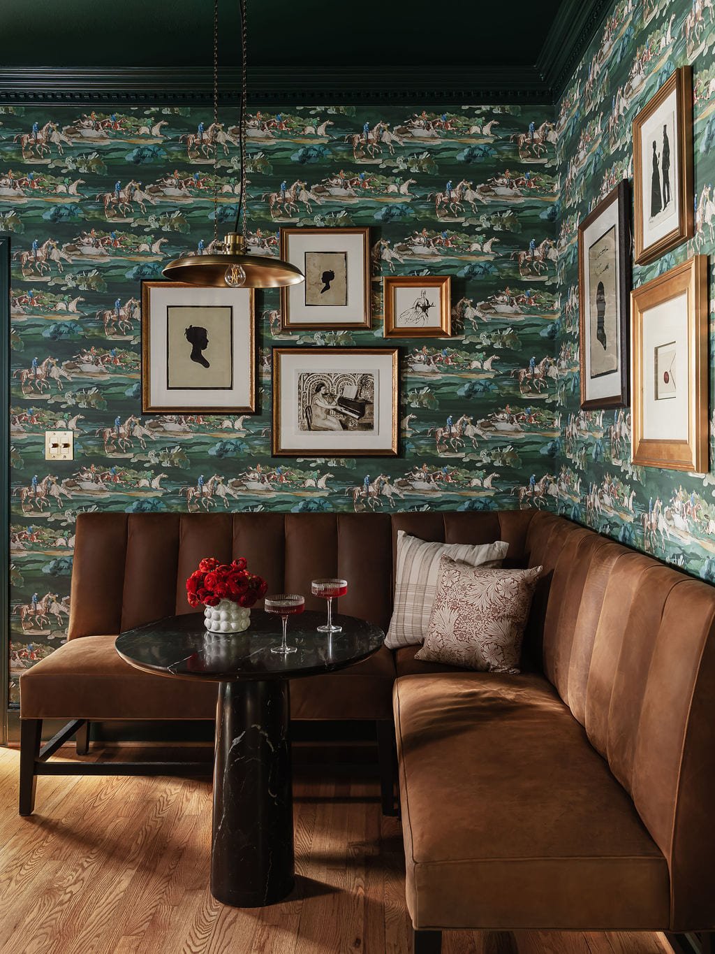 Leather banquette with toile walls and a black pedestal table