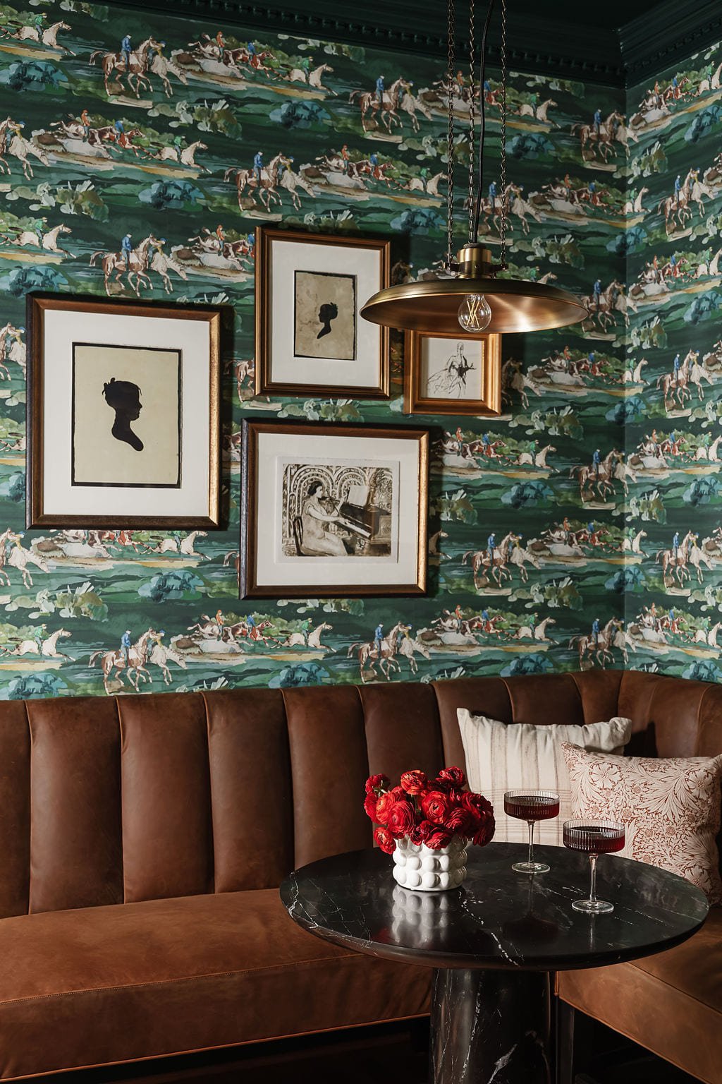 Framed sporting prints hung salon style above a leather banquette