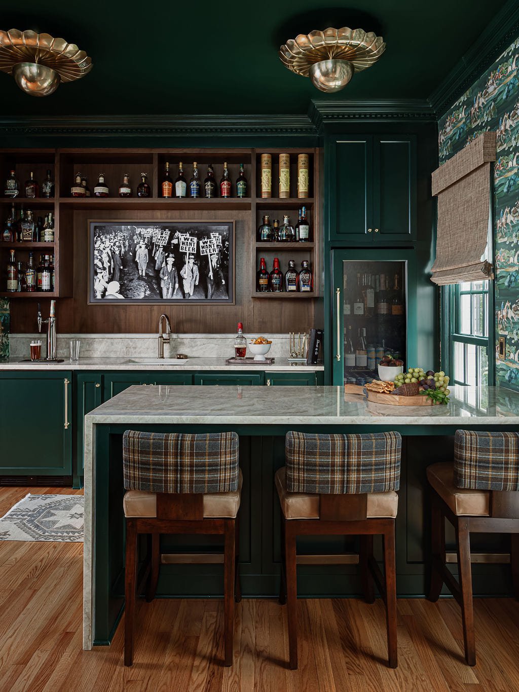 Green lacquered bar with brass flush mounts and a marble counter