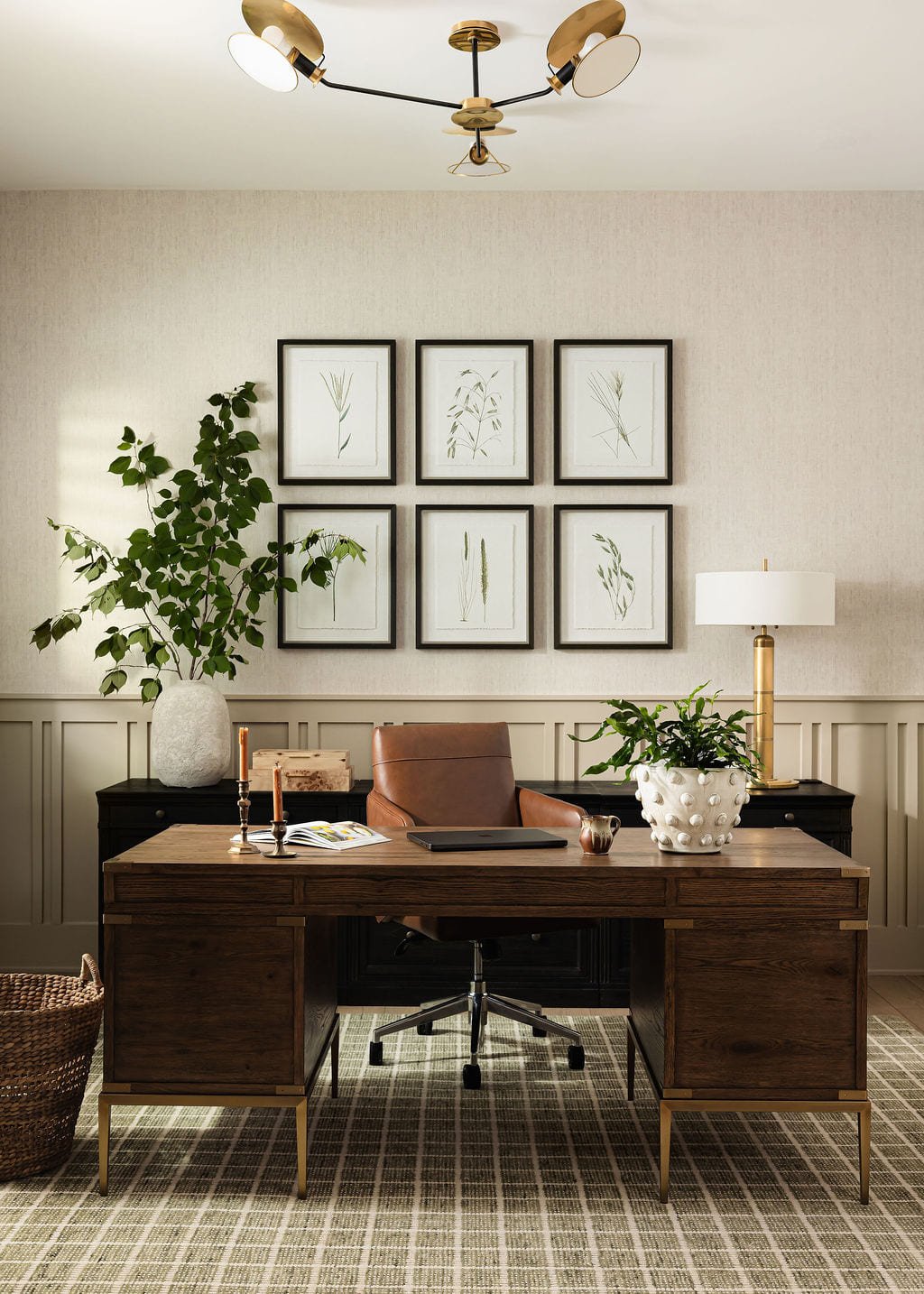 Home office with a walnut desk beneath a symmetrical gallery wall