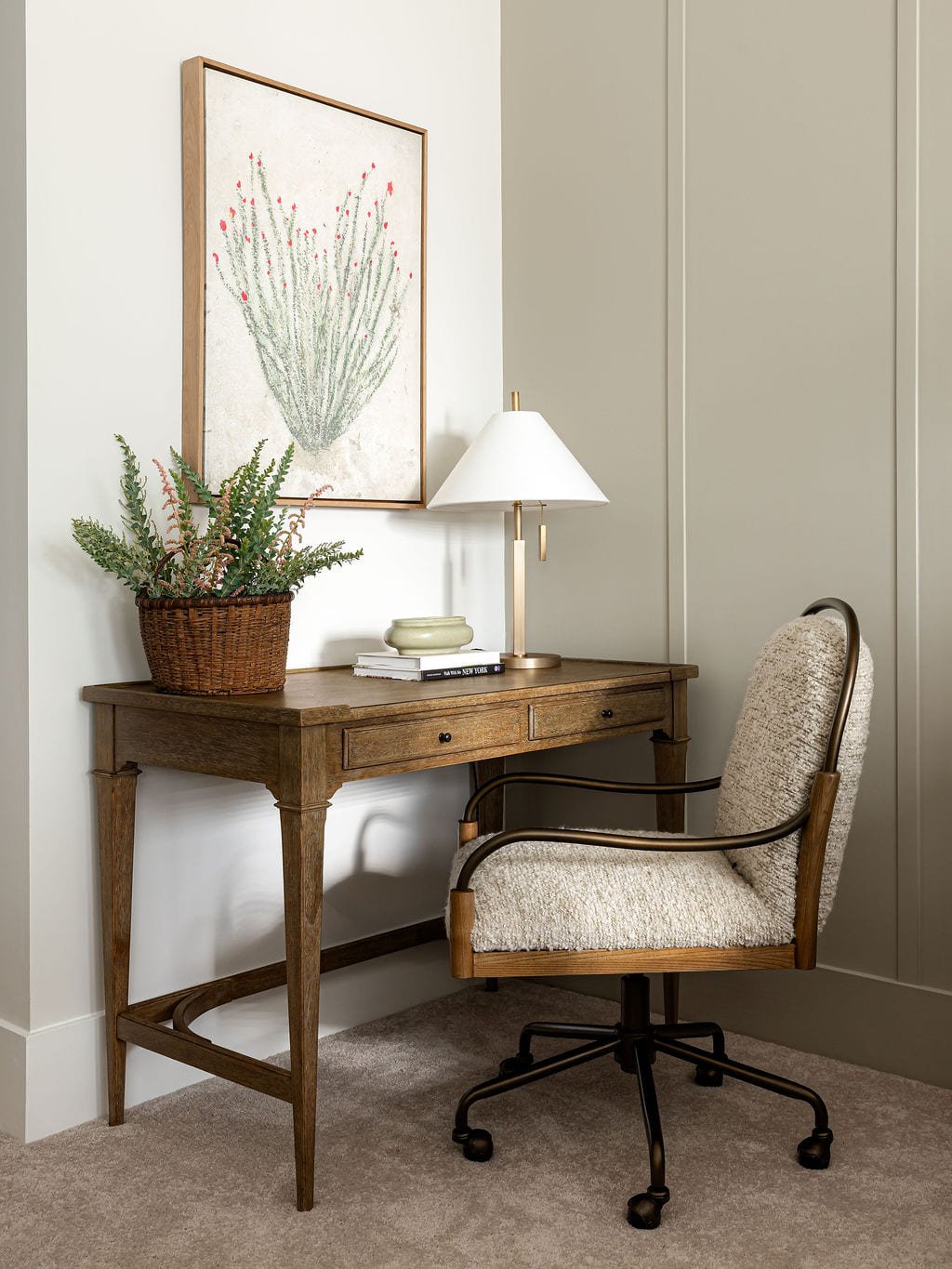 Writing desk with a cane back chair, fern, and brass table lamp