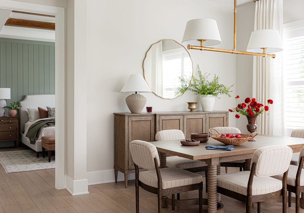 Dining room seen through a cased opening, set with red blooms