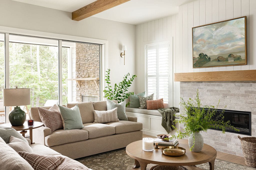 Living room with stone fireplace, beamed ceiling, and layered seating