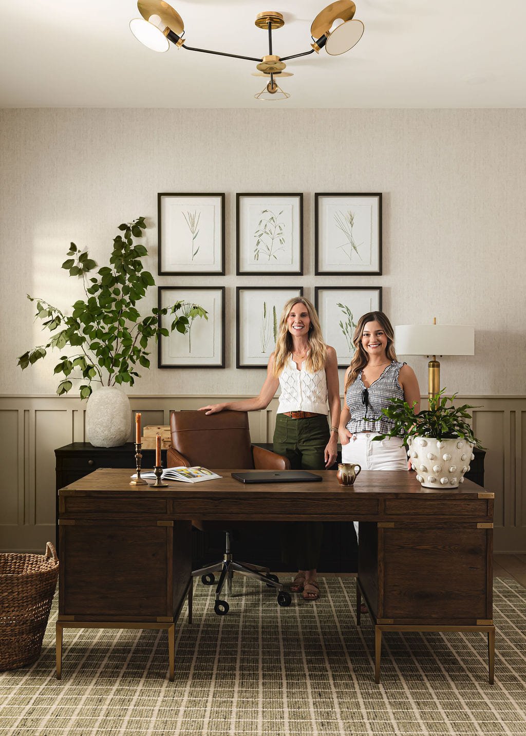 Home office with a gallery wall, walnut desk, and two designers at work