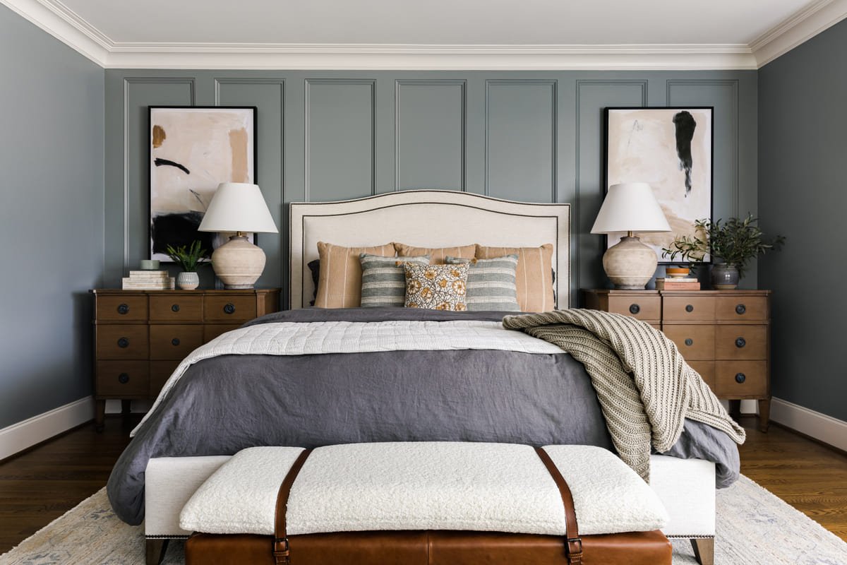Primary bed with a leather bench at the foot and a woven rug