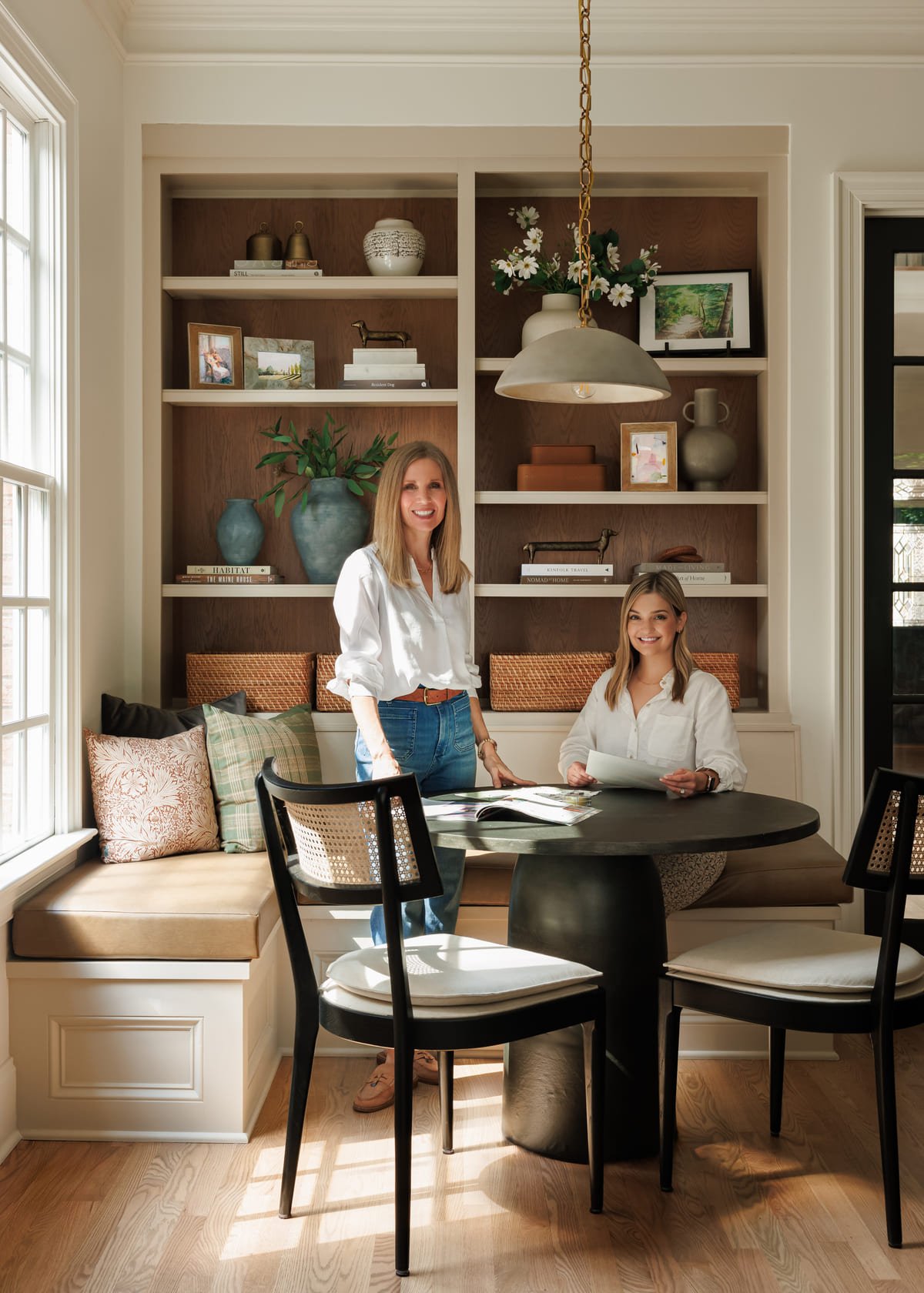 The Rebecca Driggs Interiors team reviewing a design plan at a banquette table