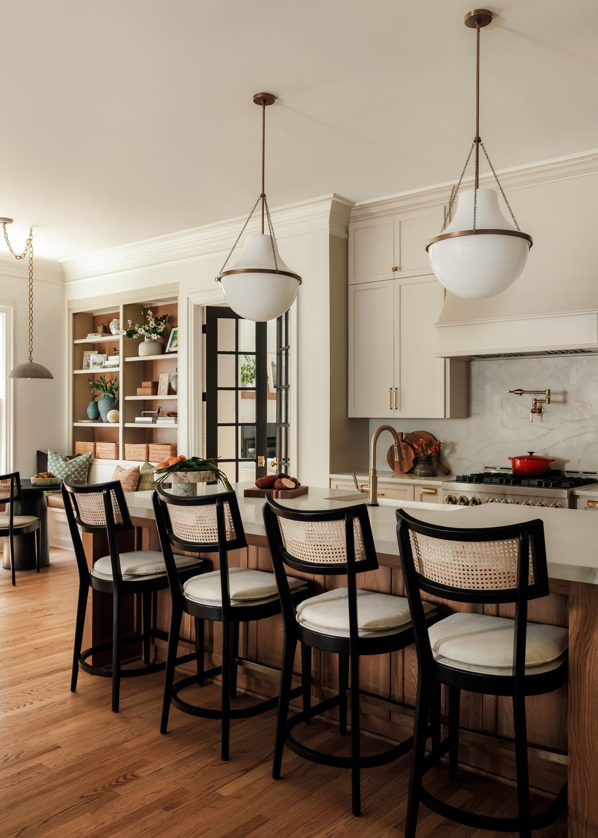 Kitchen island with black stools and paired alabaster pendants in Raleigh