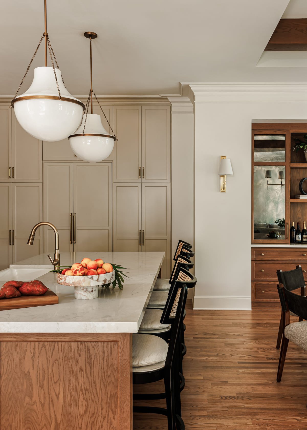 White oak island with a brass faucet and stone counters