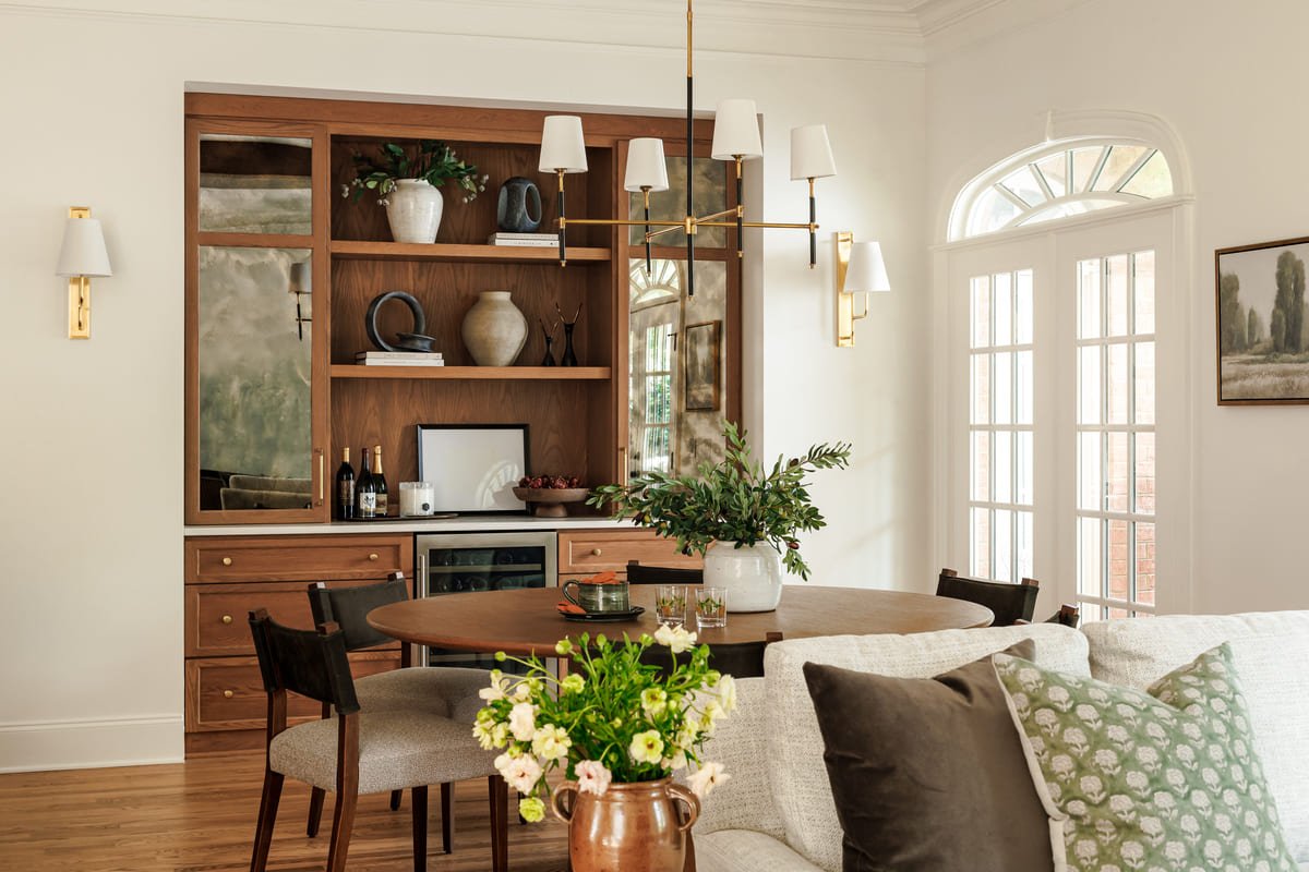 Dining area with a walnut hutch beneath arched windows