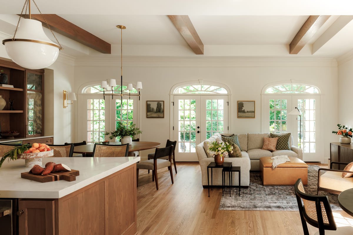 Open plan kitchen and living room with exposed beams and arched windows
