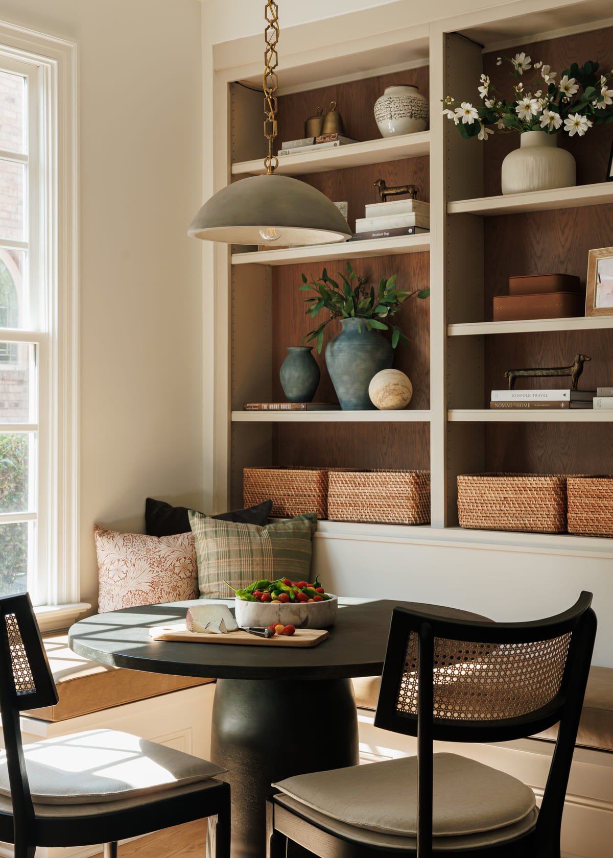 Built in shelving styled beside a breakfast banquette