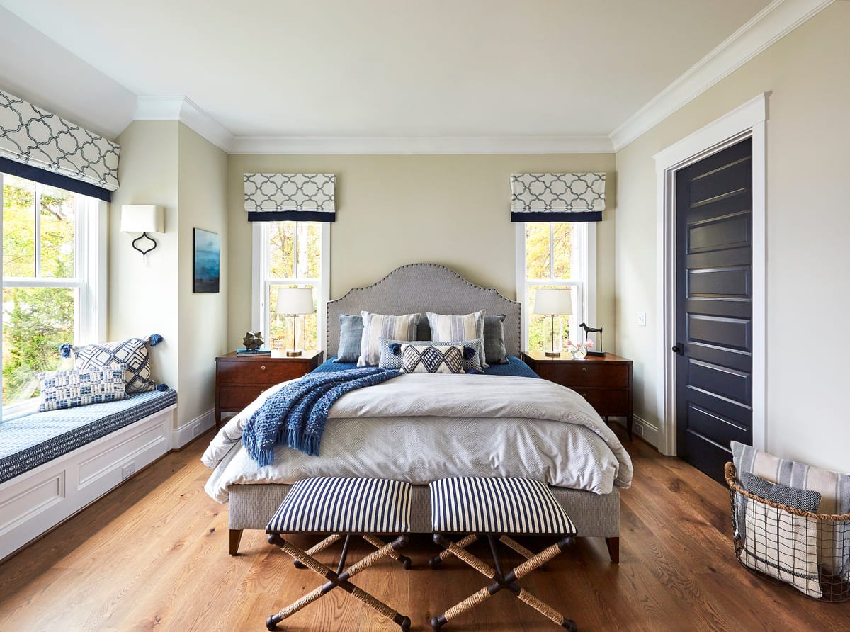 Primary bedroom with an upholstered bed flanked by window seats