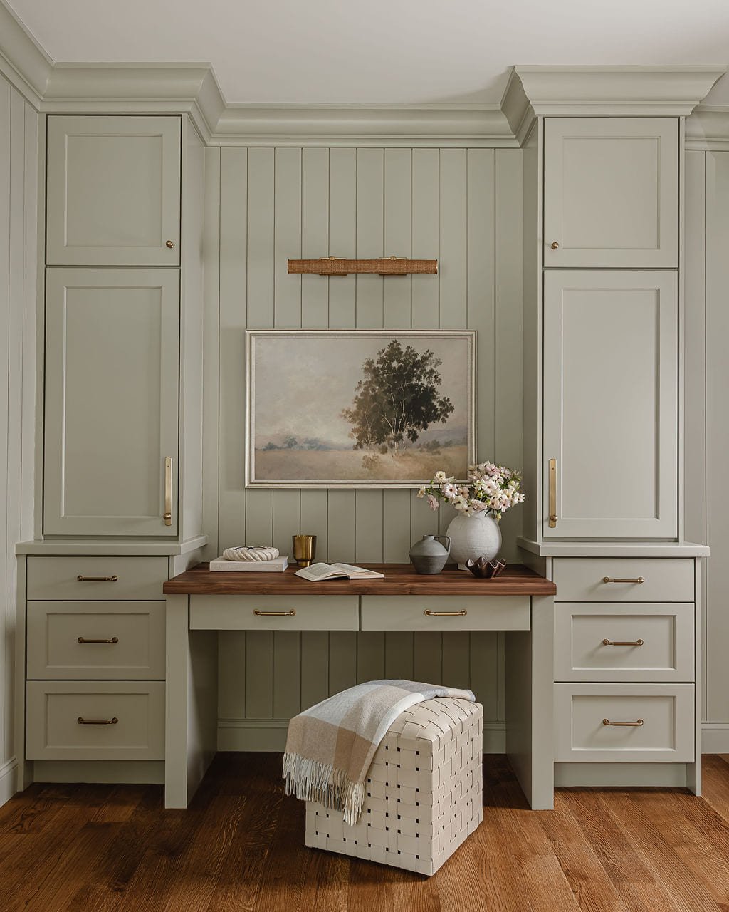 Sage green dressing room with a built in vanity and skirted stool