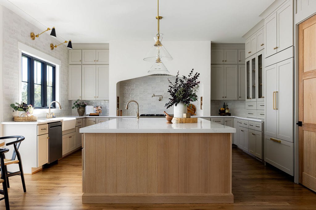White oak kitchen island beneath a plaster range hood