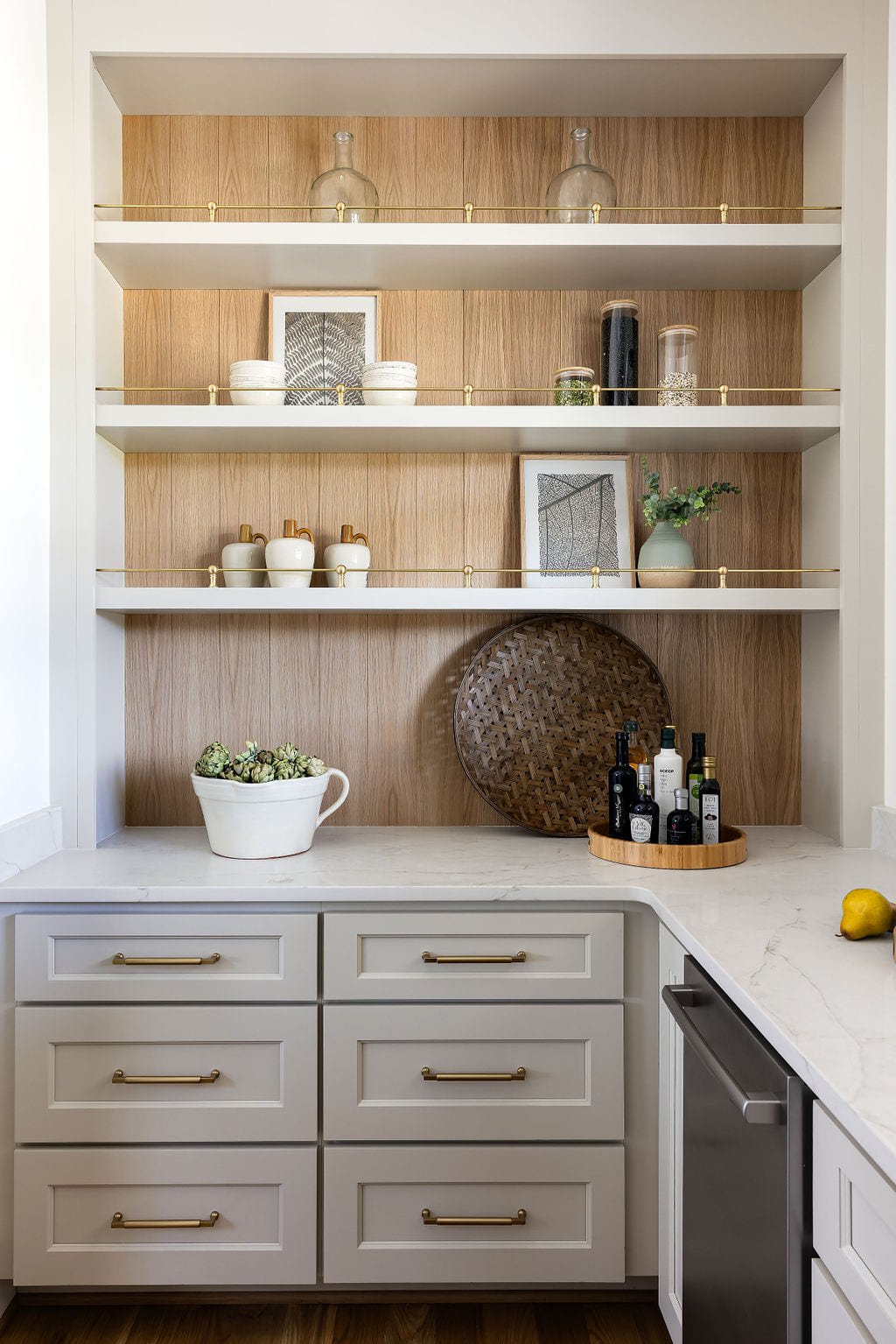 White oak open shelving above sage lower cabinets in a butler pantry