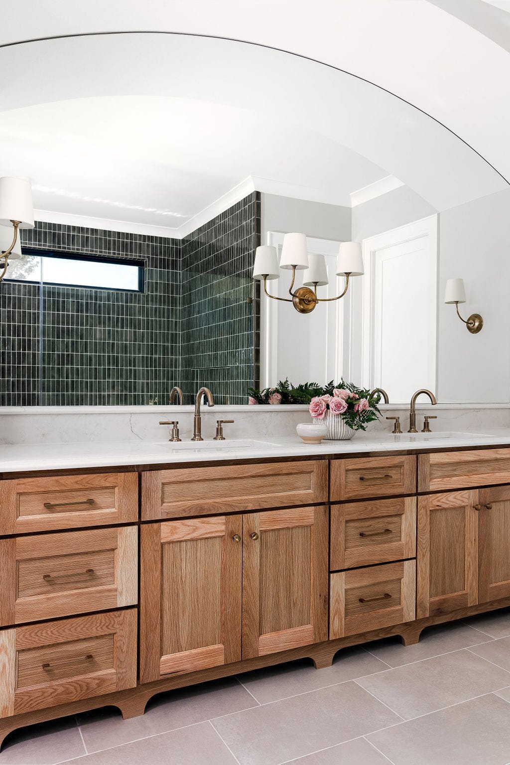 White oak double vanity beneath an arched opening