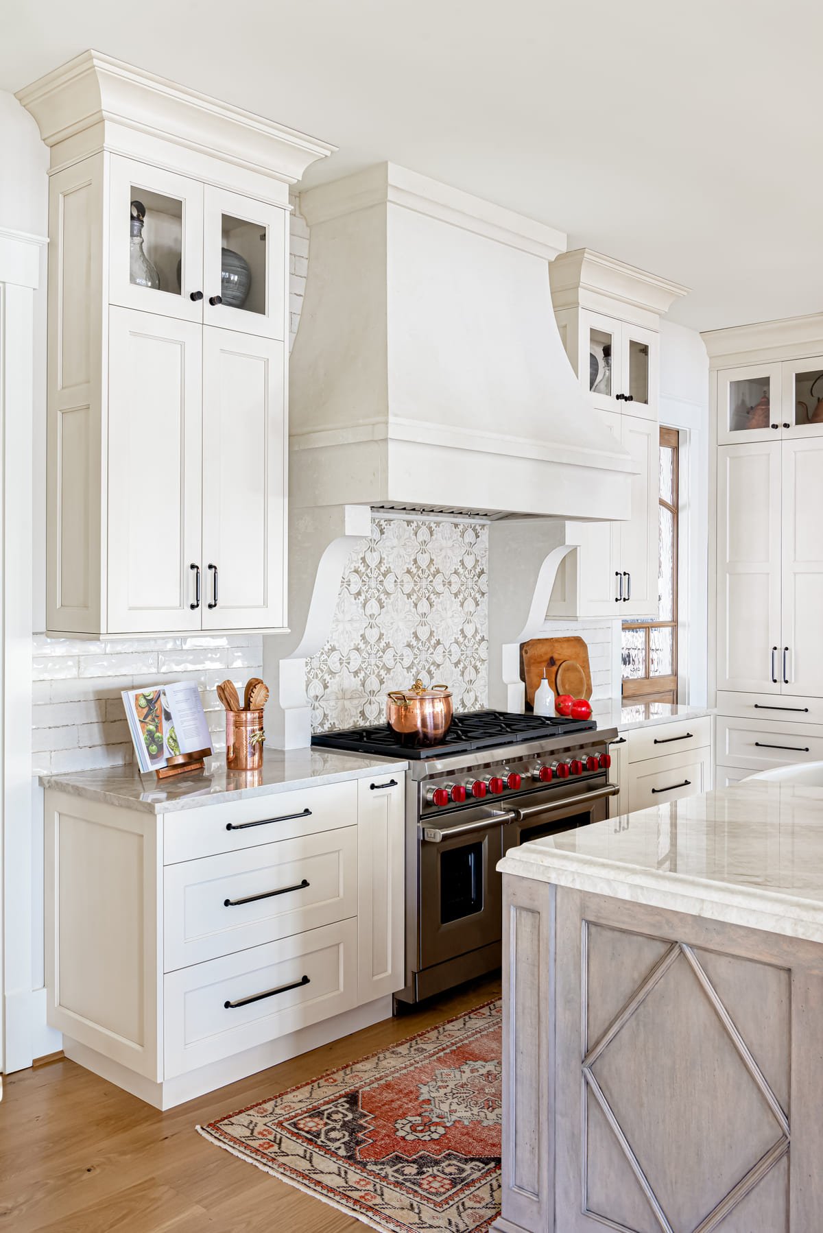 Kitchen with a professional range, white cabinetry, and an antique runner