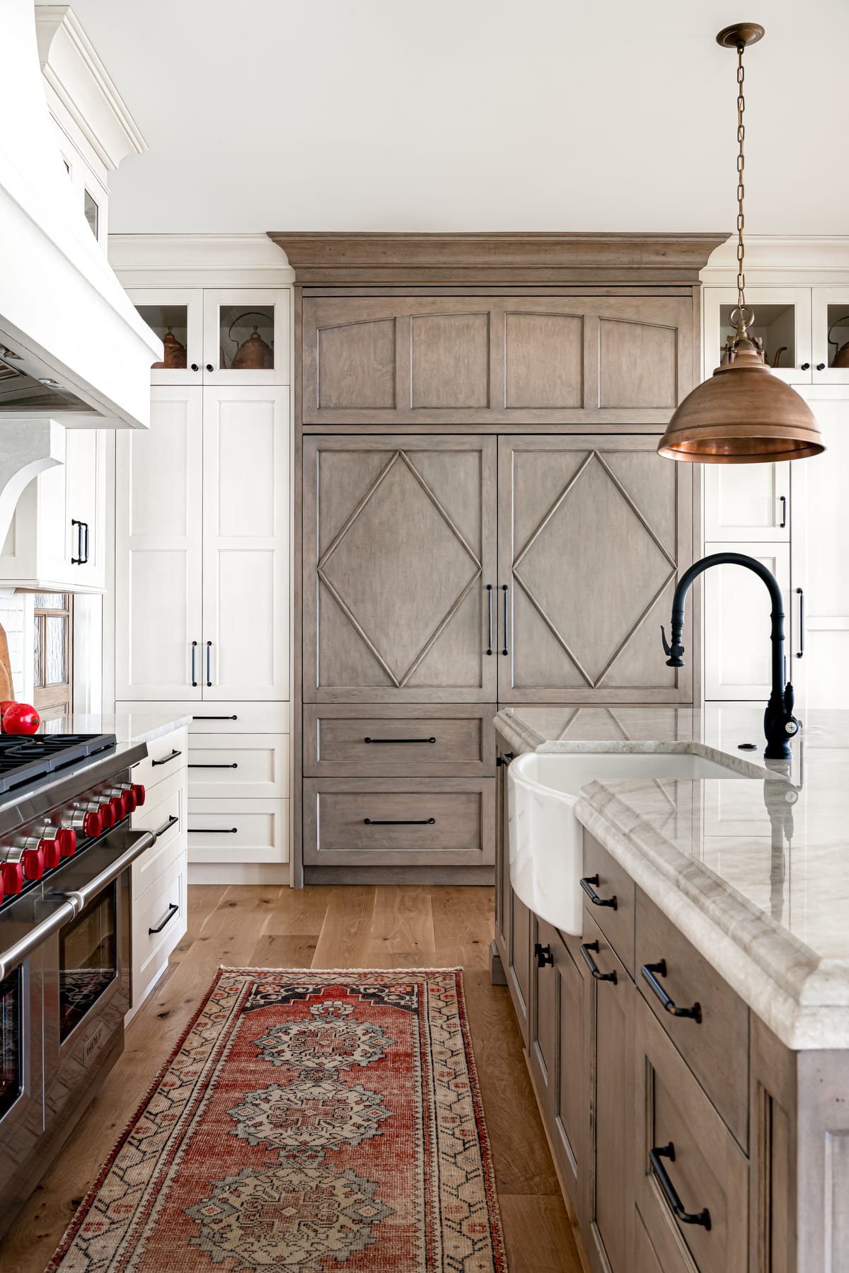 Gray oak island with copper pendants and a marble counter