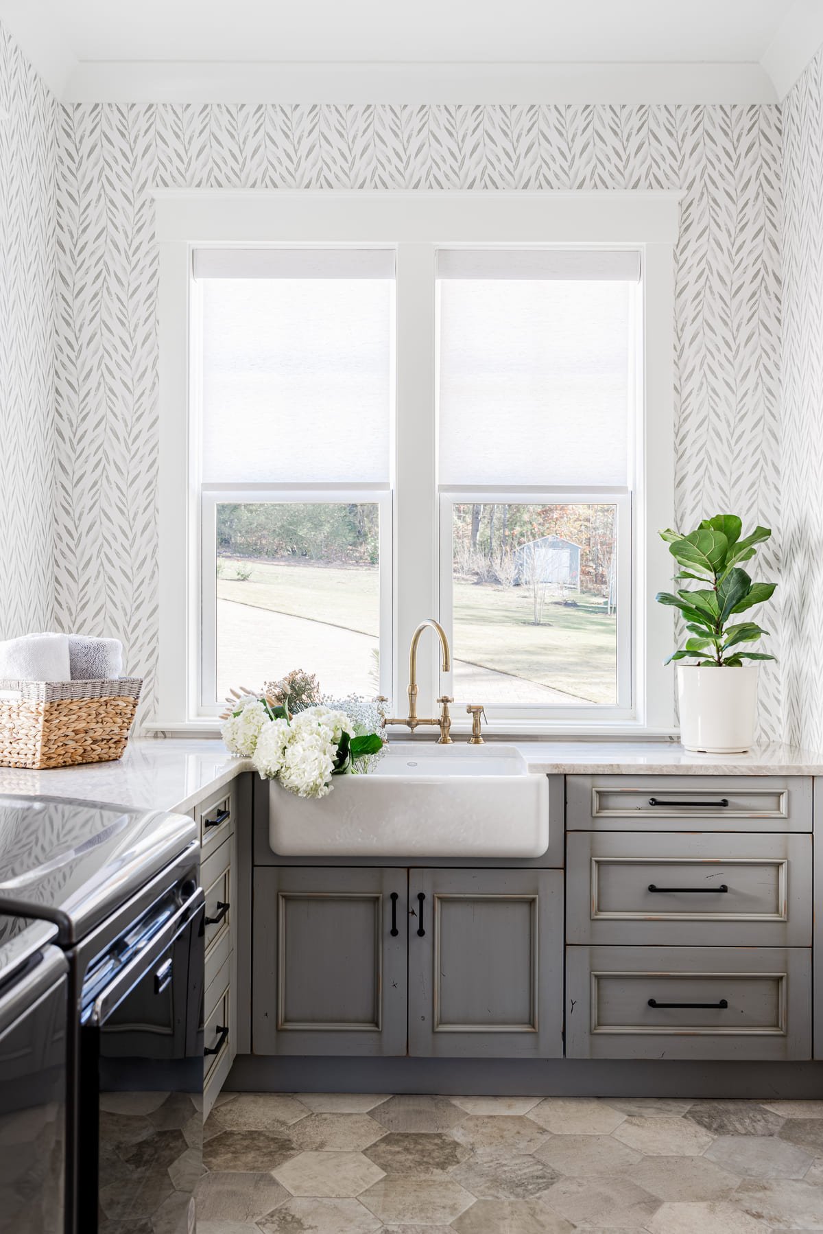 Laundry room with a farmhouse sink, brass tap, and gray cabinetry
